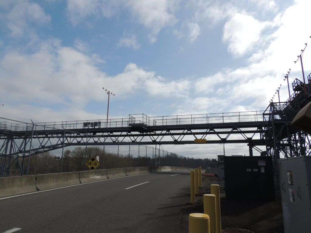 Pedestrian bridge spanning over a clear road on a partly cloudy day, earning positive reviews for its scenic view.